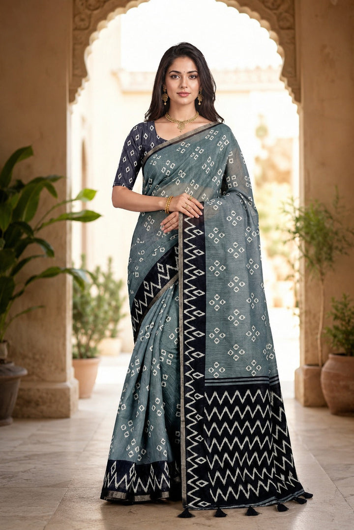 Woman wearing a traditional saree with a decorative pattern in an outdoor setting.
