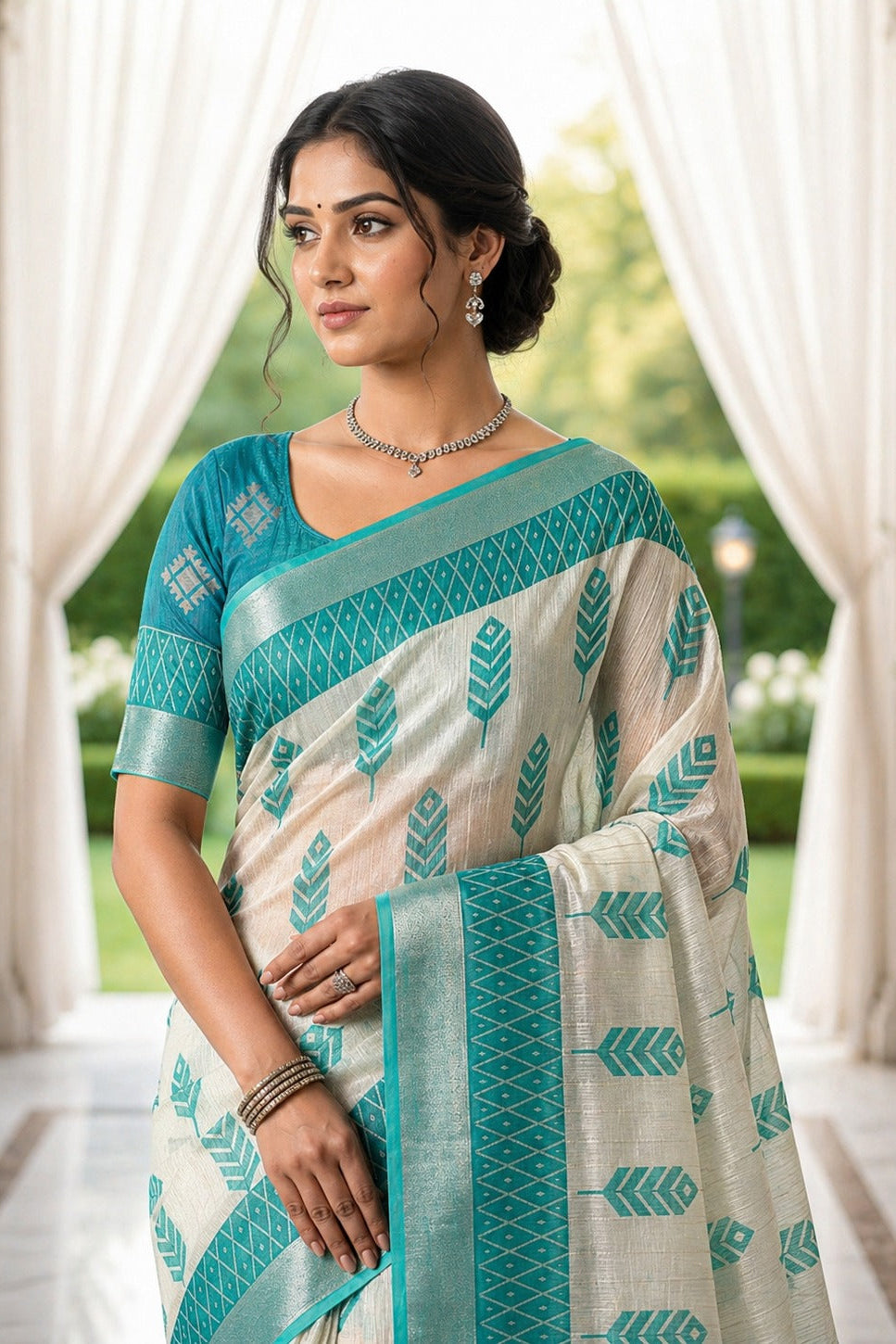 Woman wearing a traditional saree with a green and white pattern, standing in an outdoor setting.